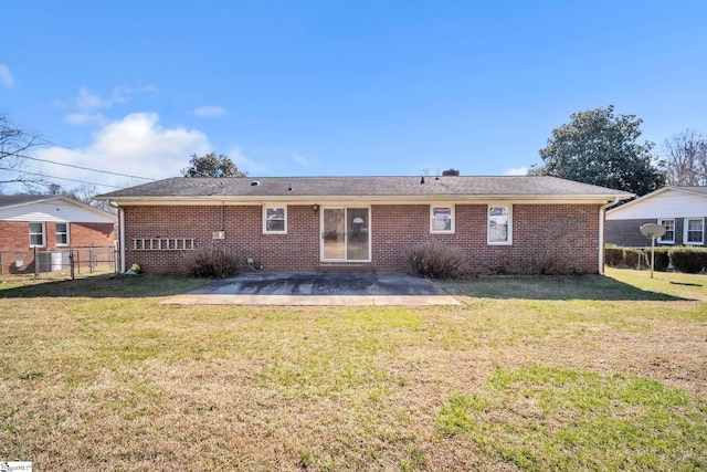 back of house with brick siding, a yard, and a patio