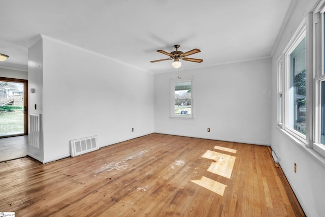 unfurnished room featuring a ceiling fan, light wood-type flooring, visible vents, and crown molding