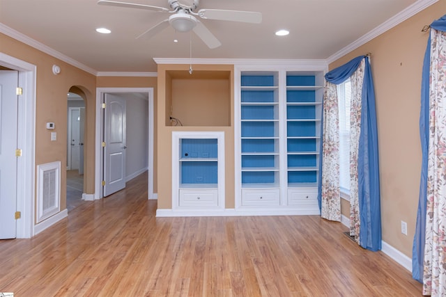 unfurnished room with visible vents, arched walkways, baseboards, light wood-style flooring, and ornamental molding