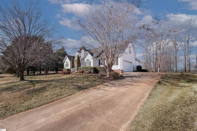 view of front of home with an attached garage, driveway, a chimney, and a front yard