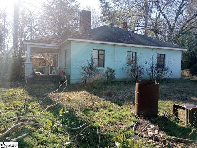 view of property exterior featuring an attached carport and a chimney