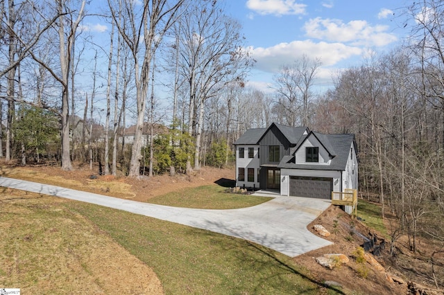 view of front of property with a garage, driveway, a front lawn, and board and batten siding