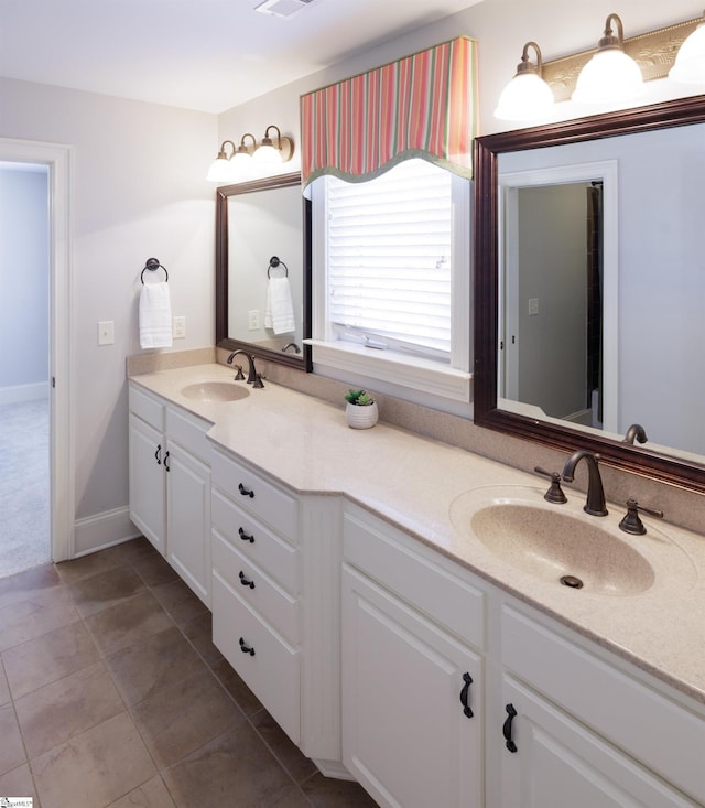 full bathroom with double vanity, tile patterned flooring, visible vents, and a sink