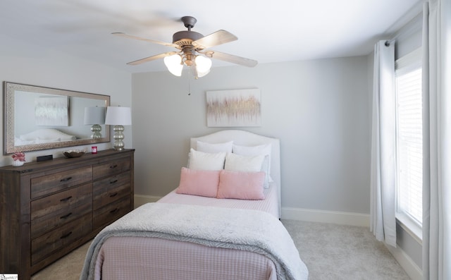 bedroom featuring a ceiling fan, light colored carpet, and baseboards