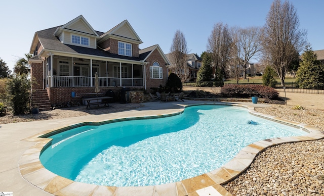 view of pool with a patio area, fence, a sunroom, and a fenced in pool