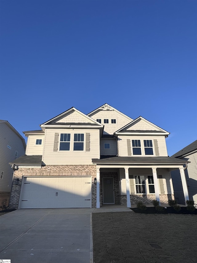 view of front of home featuring a garage, covered porch, and concrete driveway