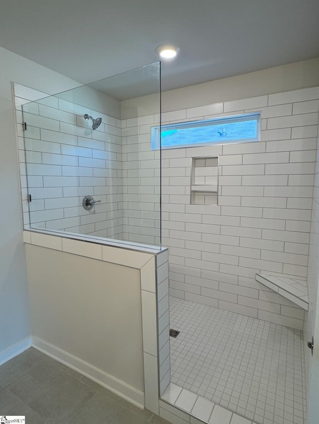 bathroom with a walk in shower, baseboards, and tile patterned floors