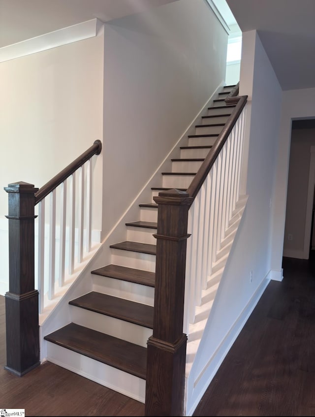 stairway with baseboards and wood finished floors