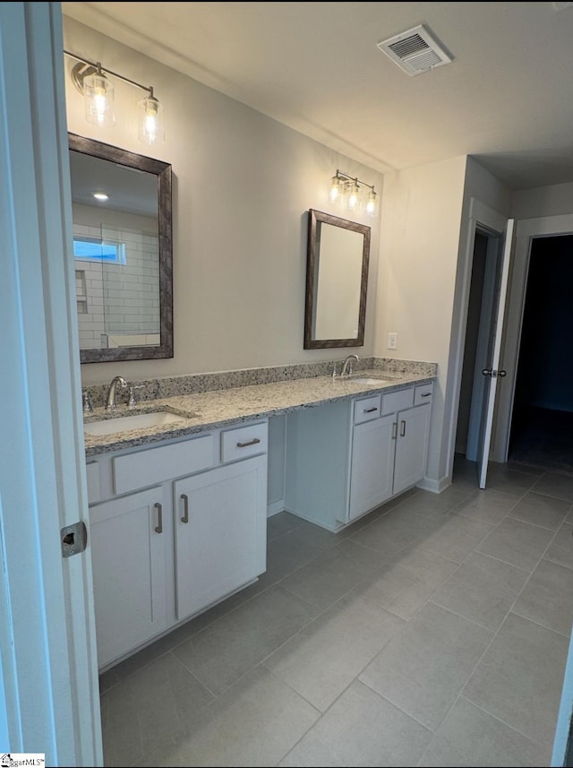 bathroom with double vanity, tile patterned flooring, a sink, and visible vents