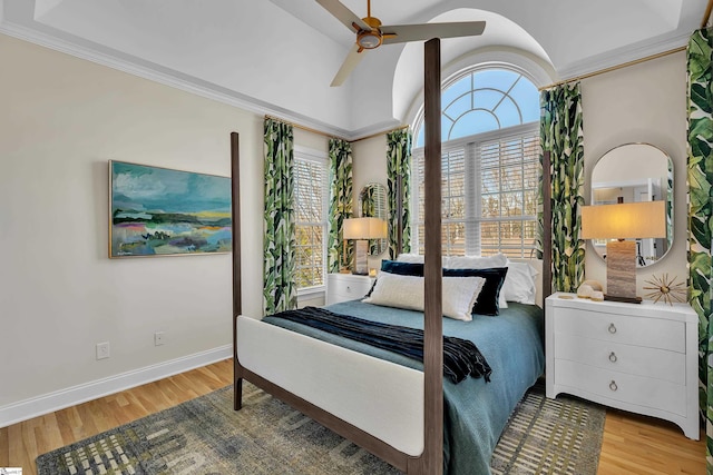 bedroom featuring light wood-style floors, lofted ceiling, multiple windows, and baseboards