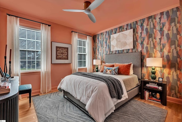 bedroom with light wood-style floors, ceiling fan, baseboards, and wallpapered walls