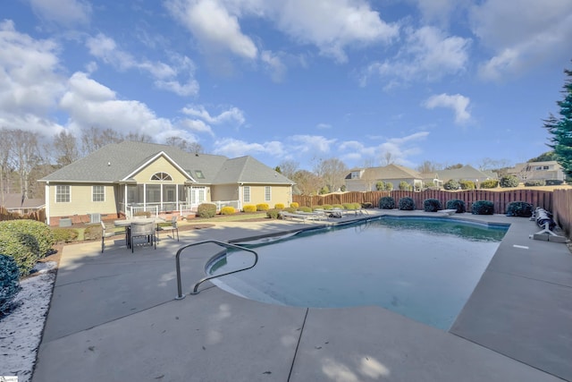 view of swimming pool with a sunroom, a patio, a fenced backyard, and a fenced in pool