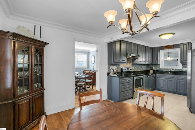 kitchen with appliances with stainless steel finishes, dark countertops, gray cabinets, and hanging light fixtures