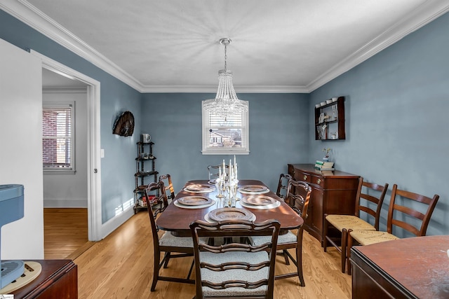 dining space with crown molding, light wood-style flooring, and baseboards