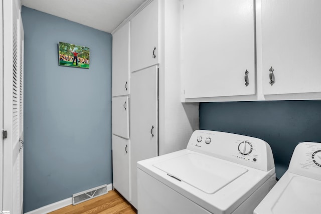 laundry area featuring cabinet space, baseboards, visible vents, independent washer and dryer, and light wood-style floors