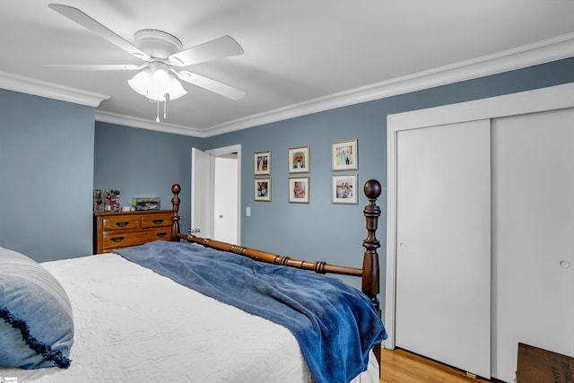 bedroom with ceiling fan, light wood-style floors, a closet, and crown molding