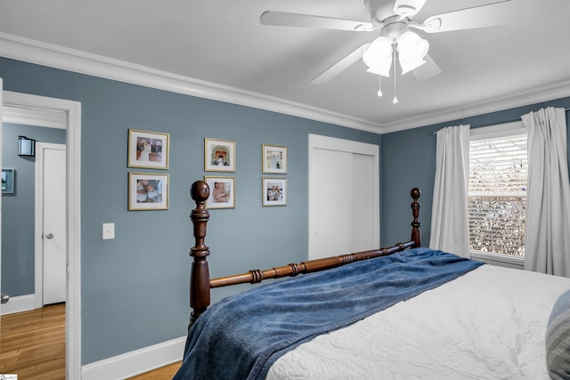 bedroom featuring baseboards, light wood finished floors, a ceiling fan, and crown molding