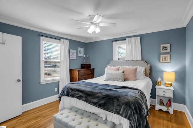 bedroom with crown molding, wood finished floors, a ceiling fan, and baseboards