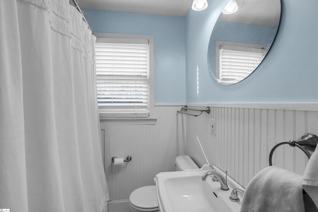 full bath with wainscoting, a sink, and toilet