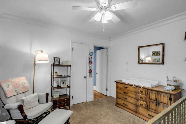 sitting room with light carpet, a ceiling fan, and crown molding