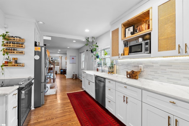 kitchen featuring light stone counters, stainless steel appliances, white cabinetry, open shelves, and a sink