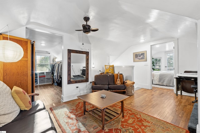 living room featuring lofted ceiling, ceiling fan, hardwood / wood-style flooring, and baseboards