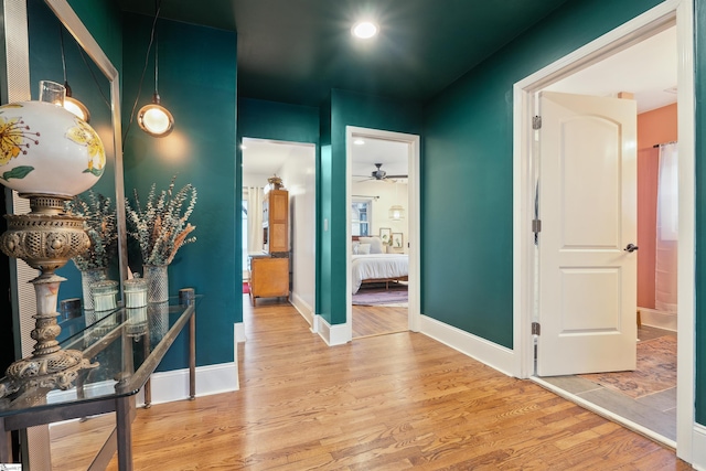 hall featuring baseboards and wood finished floors