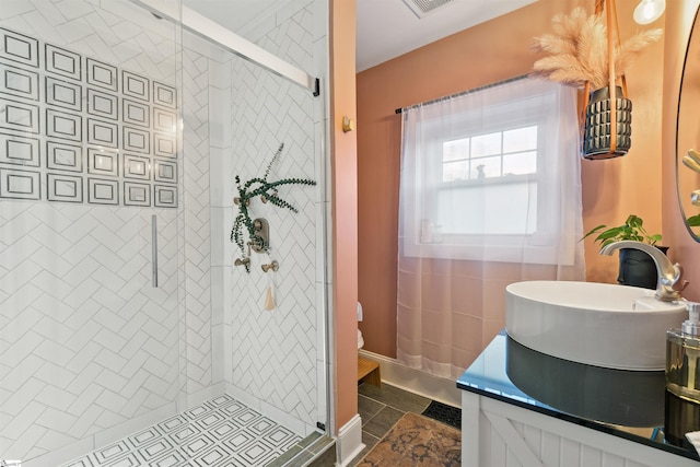 bathroom with visible vents, a tile shower, vanity, and toilet