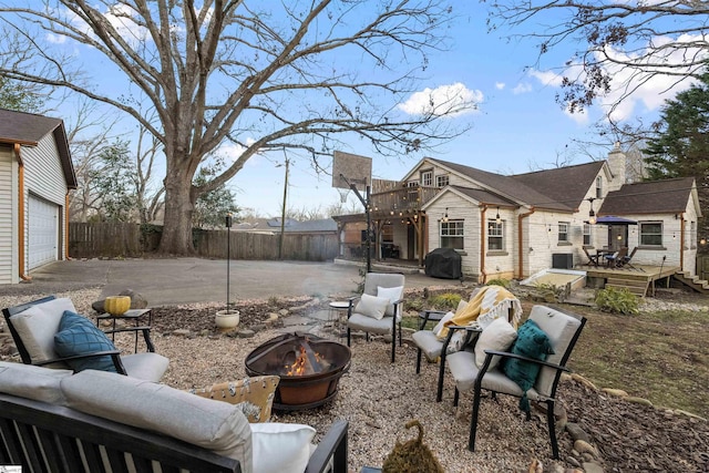 exterior space featuring a garage, an outdoor fire pit, fence, and a deck