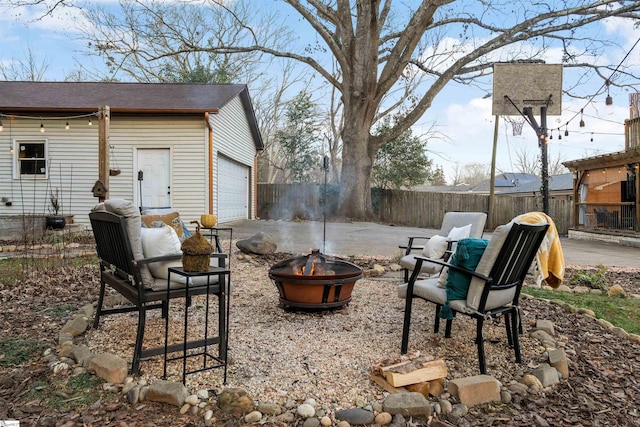 view of patio / terrace with fence, a fire pit, and an outdoor structure