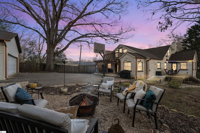 exterior space featuring a garage, an outdoor fire pit, fence, and a deck