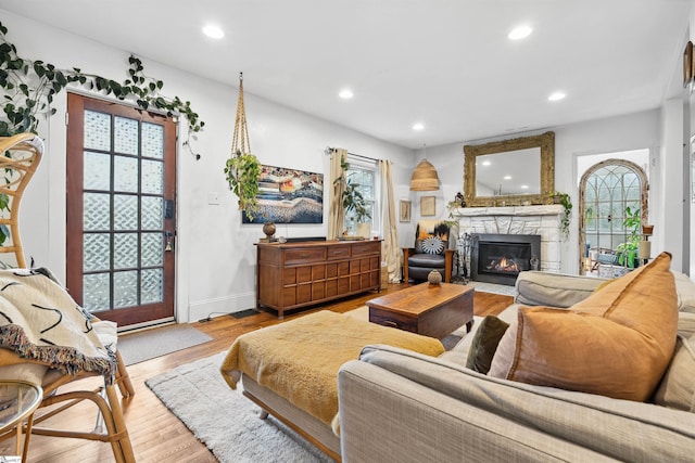 living area with a healthy amount of sunlight, a fireplace, recessed lighting, and light wood-style floors