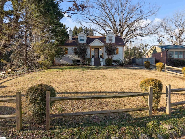 view of front of home with brick siding, a fenced front yard, and a front yard