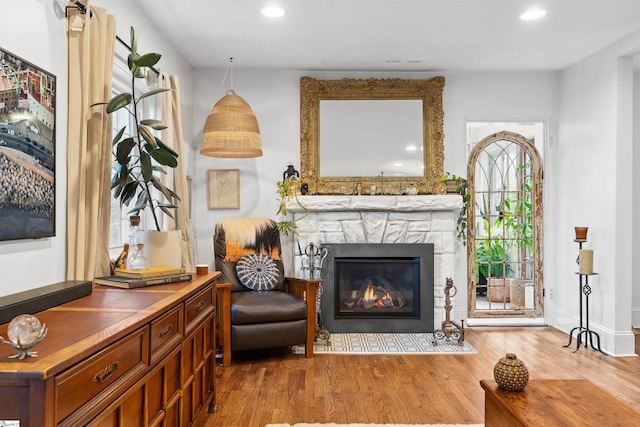 sitting room with a fireplace, wood finished floors, and recessed lighting