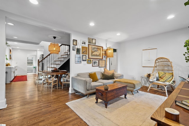 living area featuring baseboards, stairway, wood finished floors, and recessed lighting