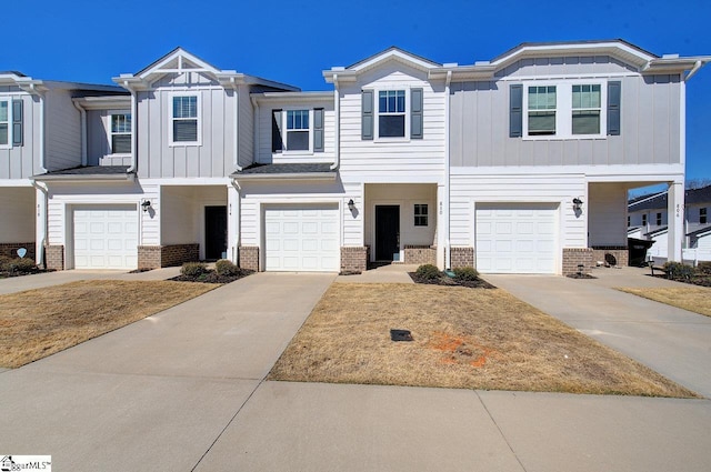 townhome / multi-family property featuring a garage, concrete driveway, brick siding, and board and batten siding