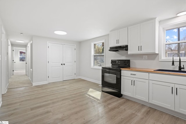 kitchen with electric range, a sink, white cabinetry, and under cabinet range hood