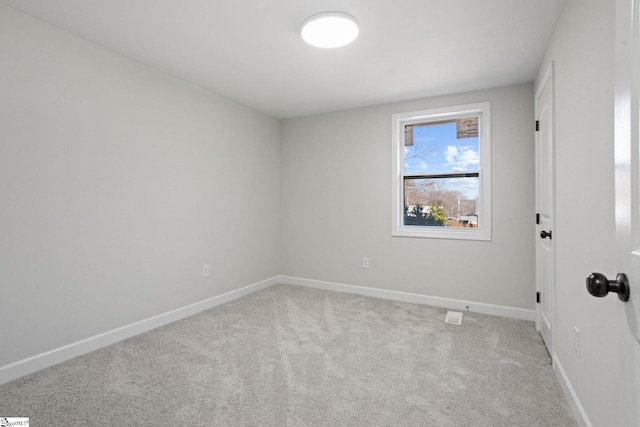 carpeted empty room featuring baseboards