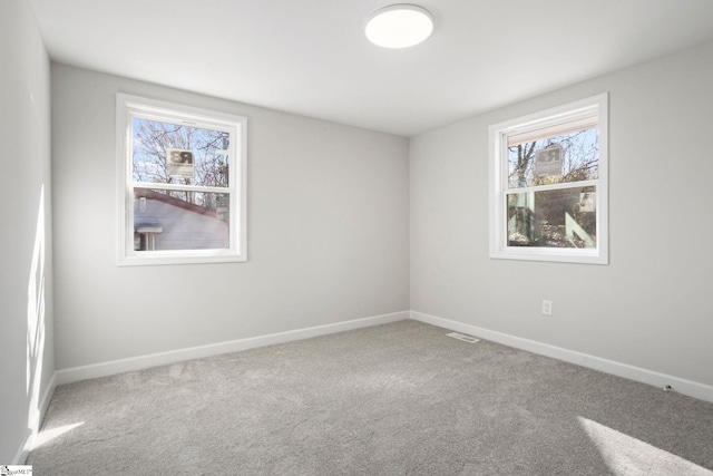 unfurnished room with carpet flooring, plenty of natural light, and baseboards