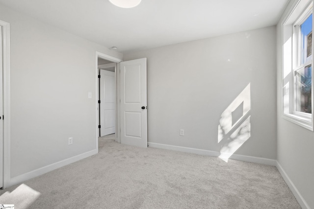 unfurnished bedroom with light carpet and baseboards