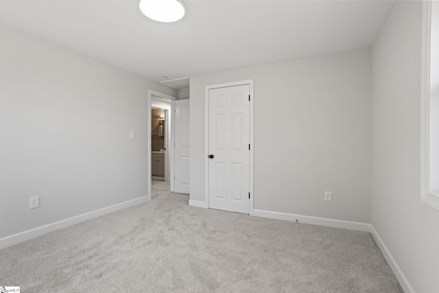 unfurnished bedroom featuring light carpet and baseboards