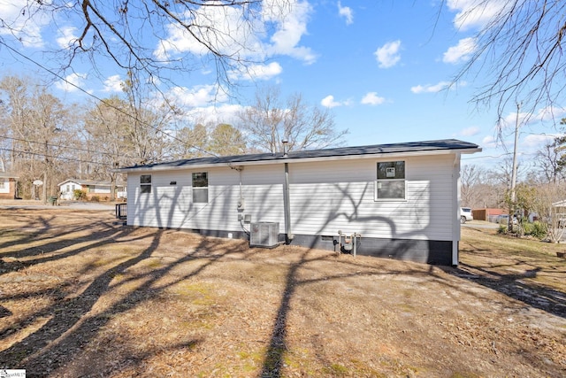 back of house featuring crawl space, a lawn, and cooling unit