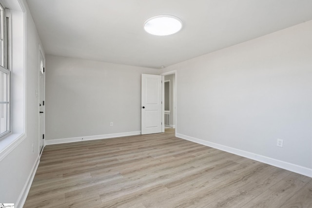 unfurnished room featuring light wood-style flooring and baseboards