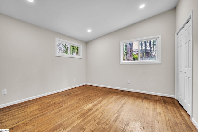 unfurnished bedroom with lofted ceiling, light wood-style flooring, baseboards, and recessed lighting