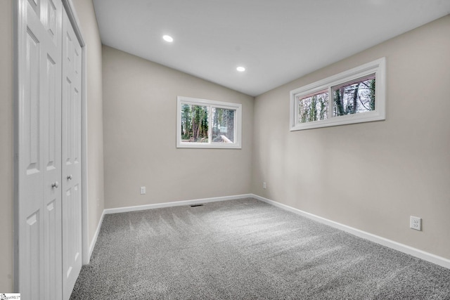 unfurnished bedroom featuring carpet floors, lofted ceiling, a closet, recessed lighting, and baseboards