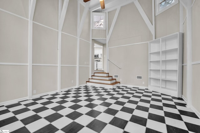 basement with ceiling fan, stairway, visible vents, and baseboards