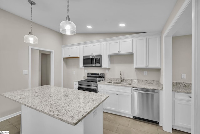 kitchen with hanging light fixtures, white cabinetry, stainless steel appliances, and a sink