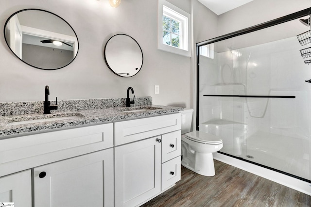 bathroom with a stall shower, a sink, and wood finished floors