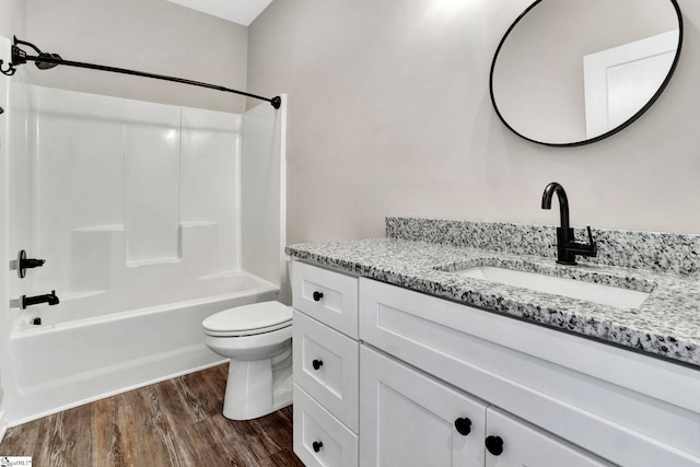 full bath featuring toilet, vanity, wood finished floors, and bathing tub / shower combination