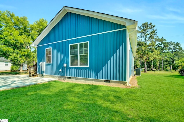 view of side of home featuring crawl space, cooling unit, and a lawn